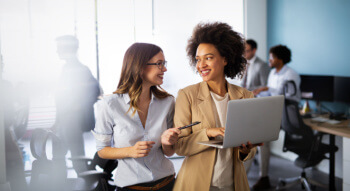 two colleagues talking over a laptop 