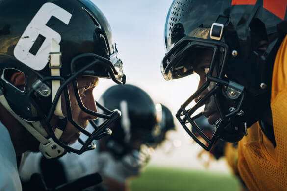 Two football players touching helmets