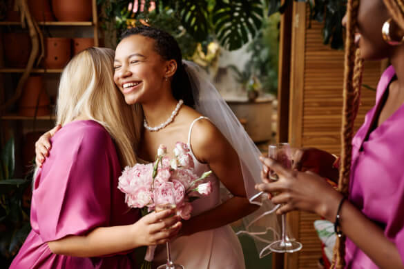 a bride and bridesmaid hugging 